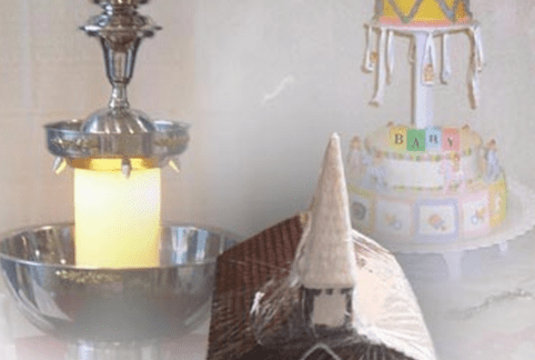 A collage of three objects: a metal basin holding a lit candle with a floral arrangement on top, a tiered cake with baby-themed decorations and a teddy bear at the top, and a model of a small church with a pointed steeple.